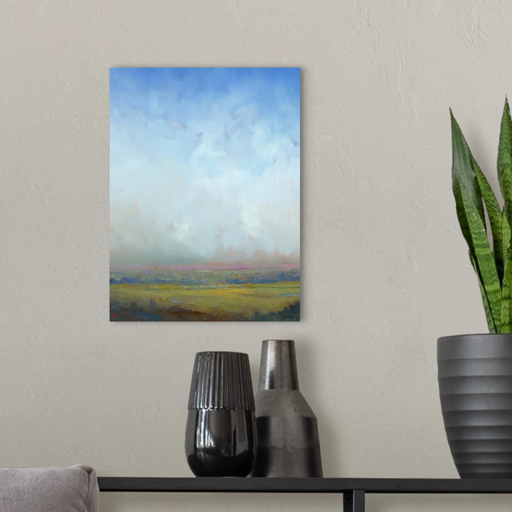 A modern room featuring Contemporary landscape painting of a green field with towering clouds in the sky above.