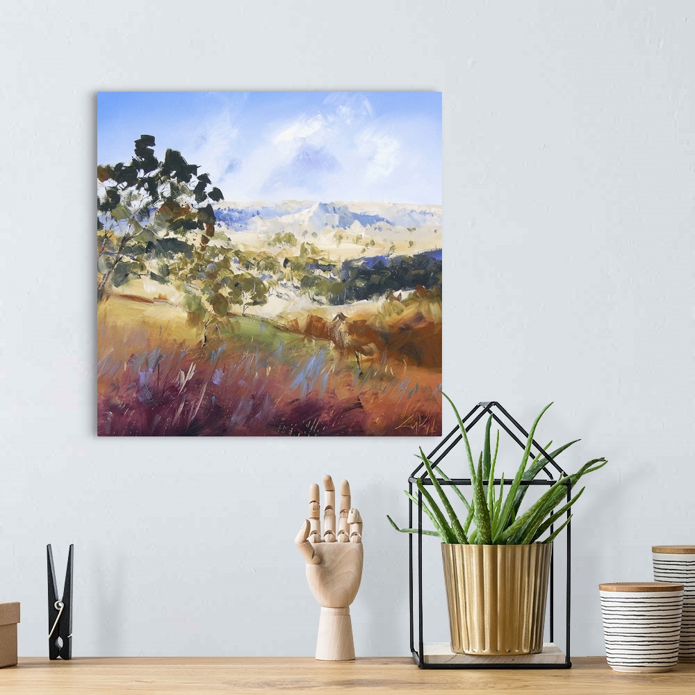 A bohemian room featuring Contemporary painting of a valley landscape with trees and mountains in the distance.