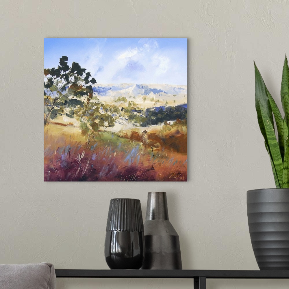 A modern room featuring Contemporary painting of a valley landscape with trees and mountains in the distance.
