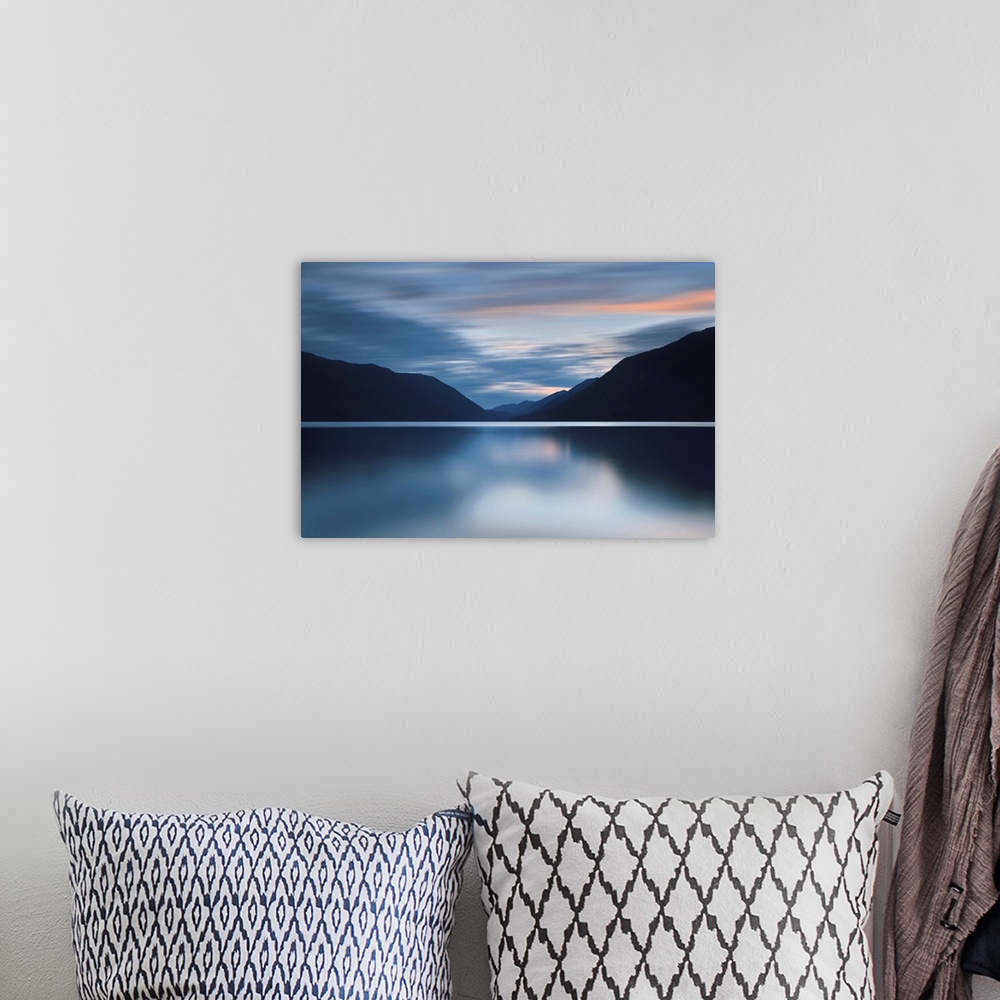 A bohemian room featuring A photograph of an idyllic wilderness scene with mountains and still lake.