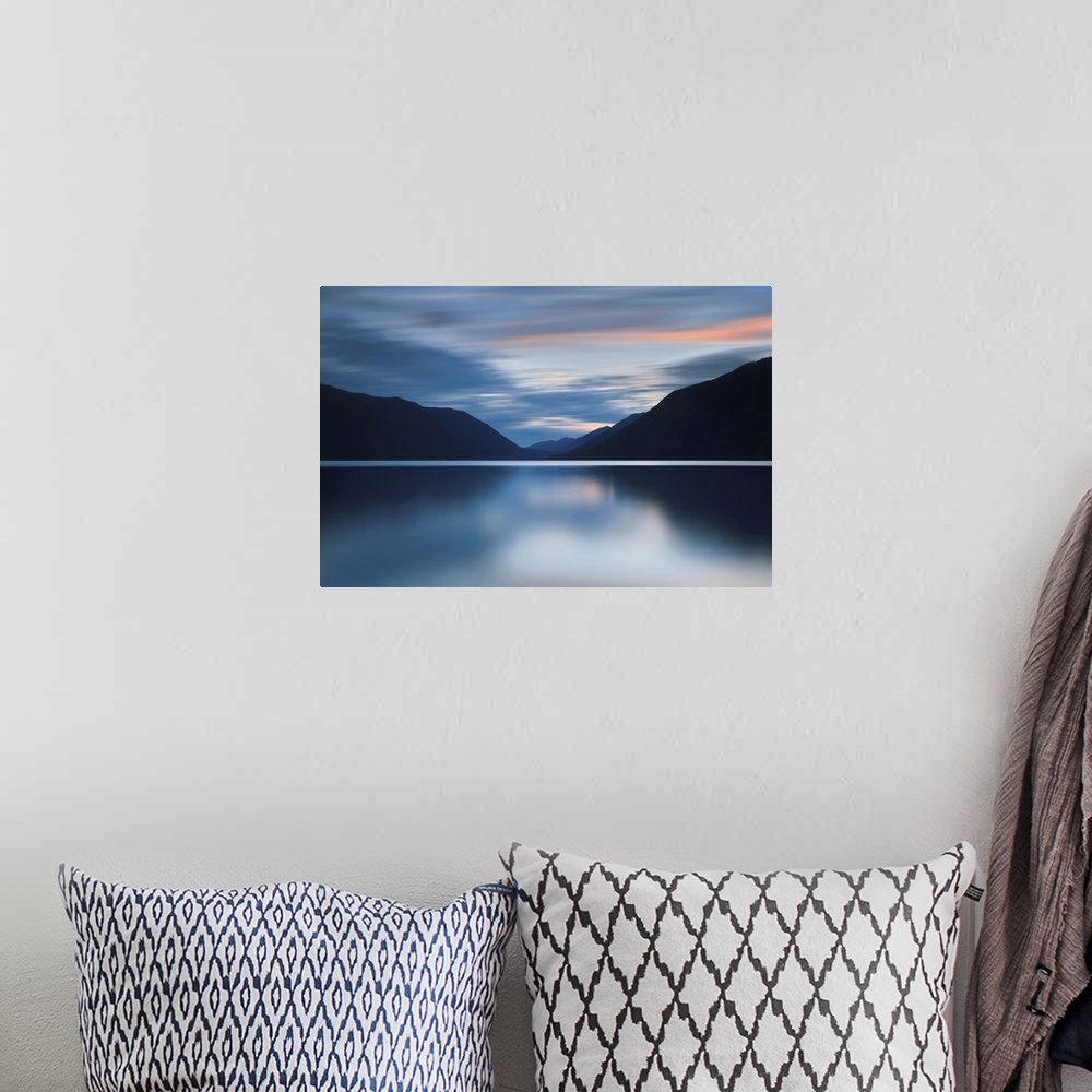 A bohemian room featuring A photograph of an idyllic wilderness scene with mountains and still lake.