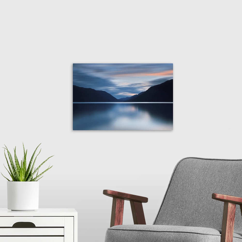 A modern room featuring A photograph of an idyllic wilderness scene with mountains and still lake.