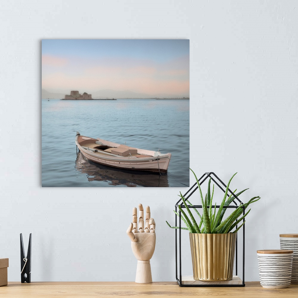 A bohemian room featuring A single boat floating in the calm waters of the Mediterranean with a nearby castle in the backgr...