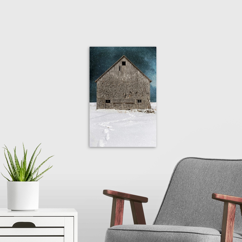 A modern room featuring An old abandoned barn in a winter snow storm with footprints.