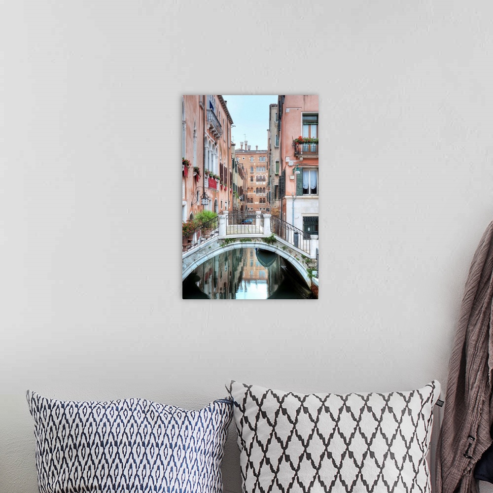 A bohemian room featuring A vertical scene of a walking bridge over a canal with the city reflecting in the water in Venice...
