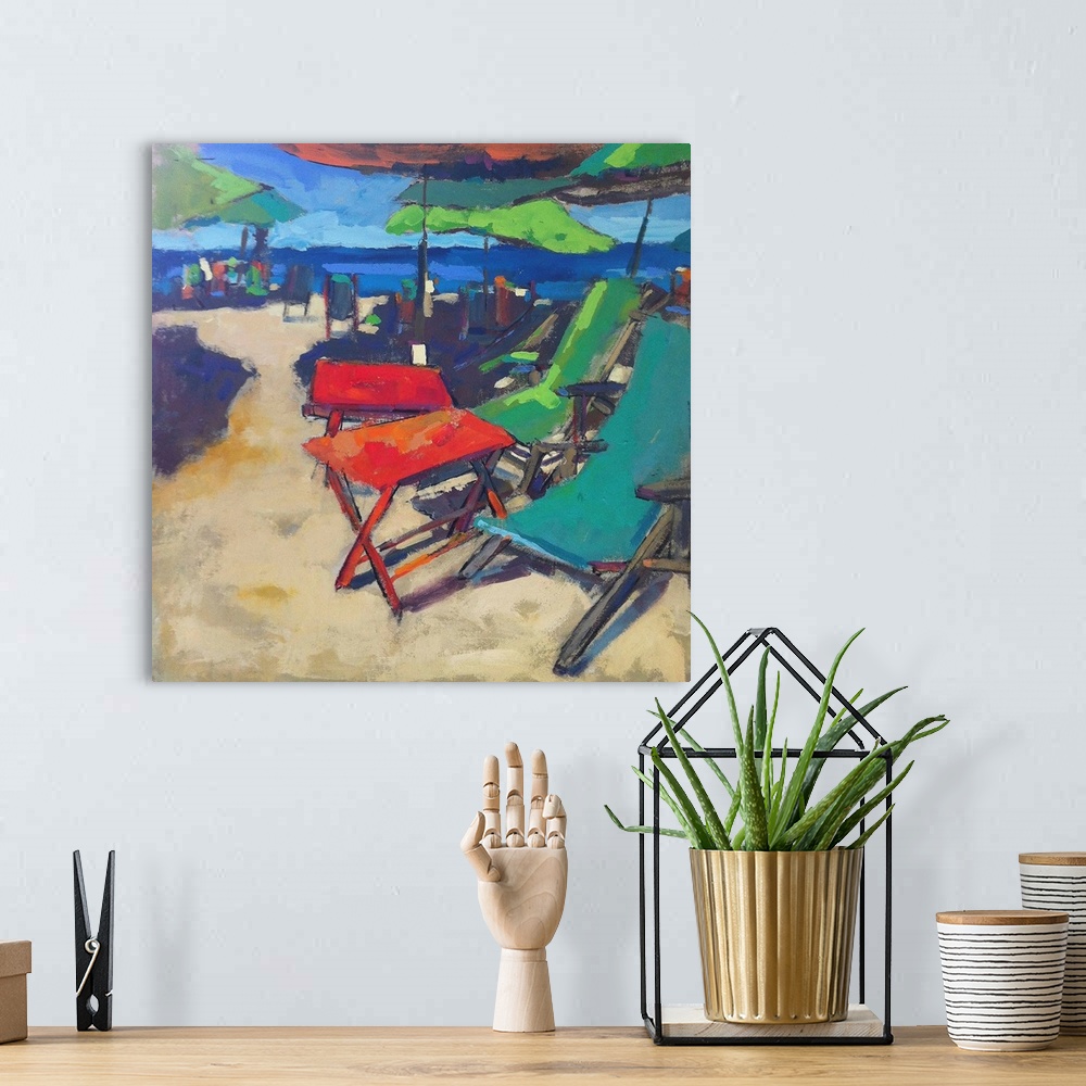 A bohemian room featuring A coastal themed painting of colorful chairs sitting on a beach.