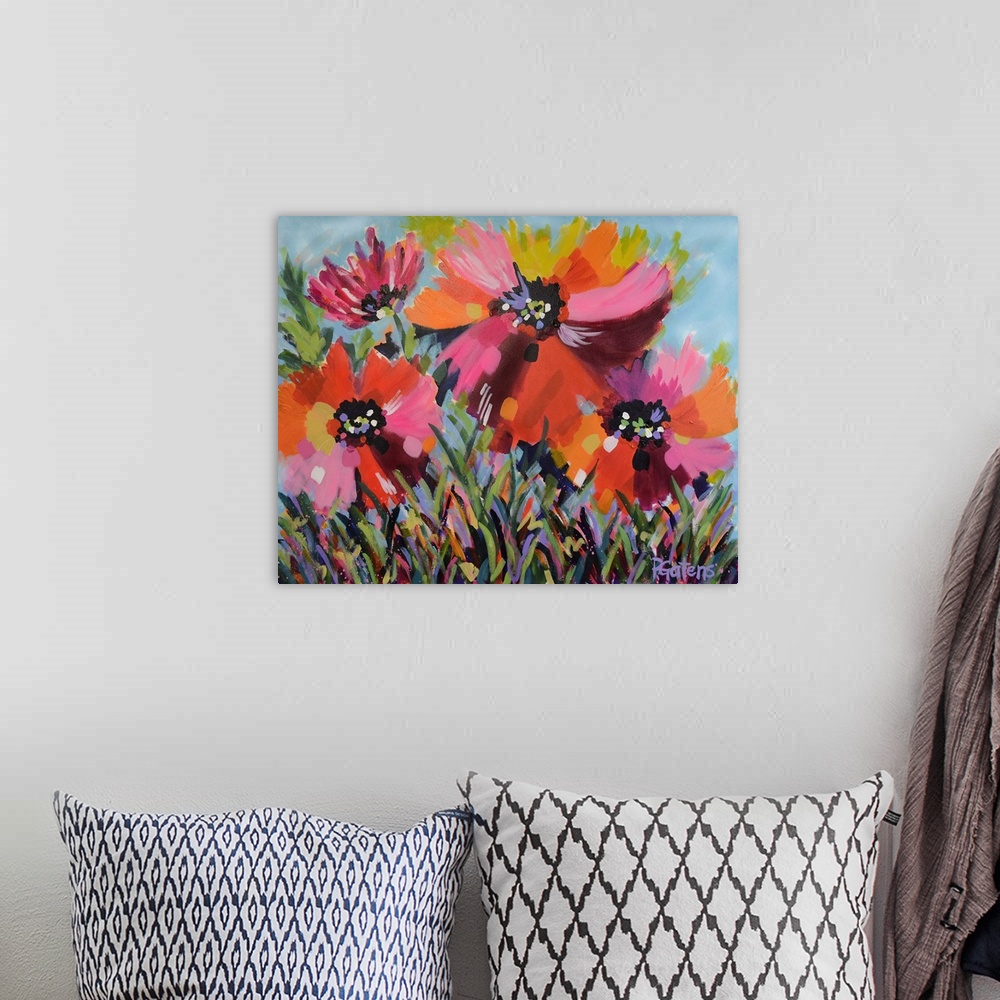 A bohemian room featuring A horizontal abstract painting of bright poppies in colors of yellow, orange and pink.