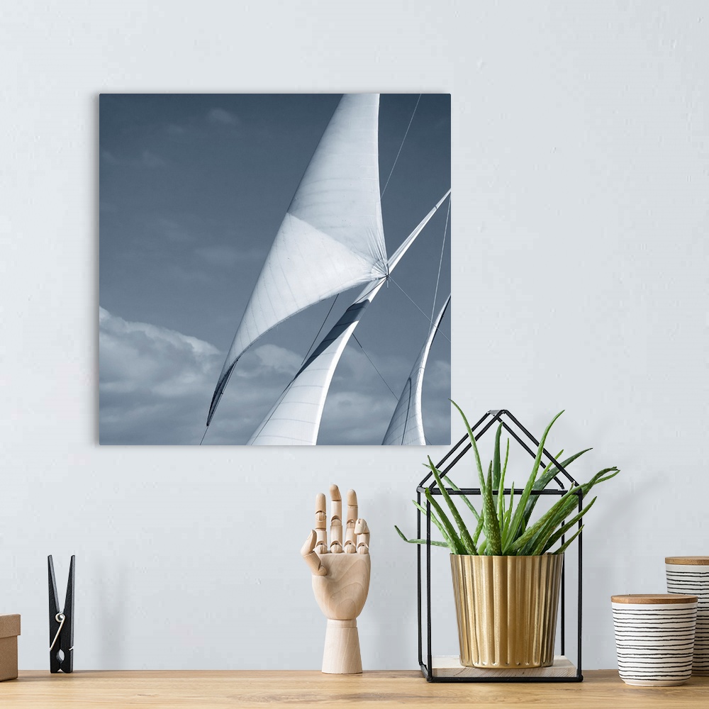 A bohemian room featuring Black and white photograph of three sails against a cloudy sky.