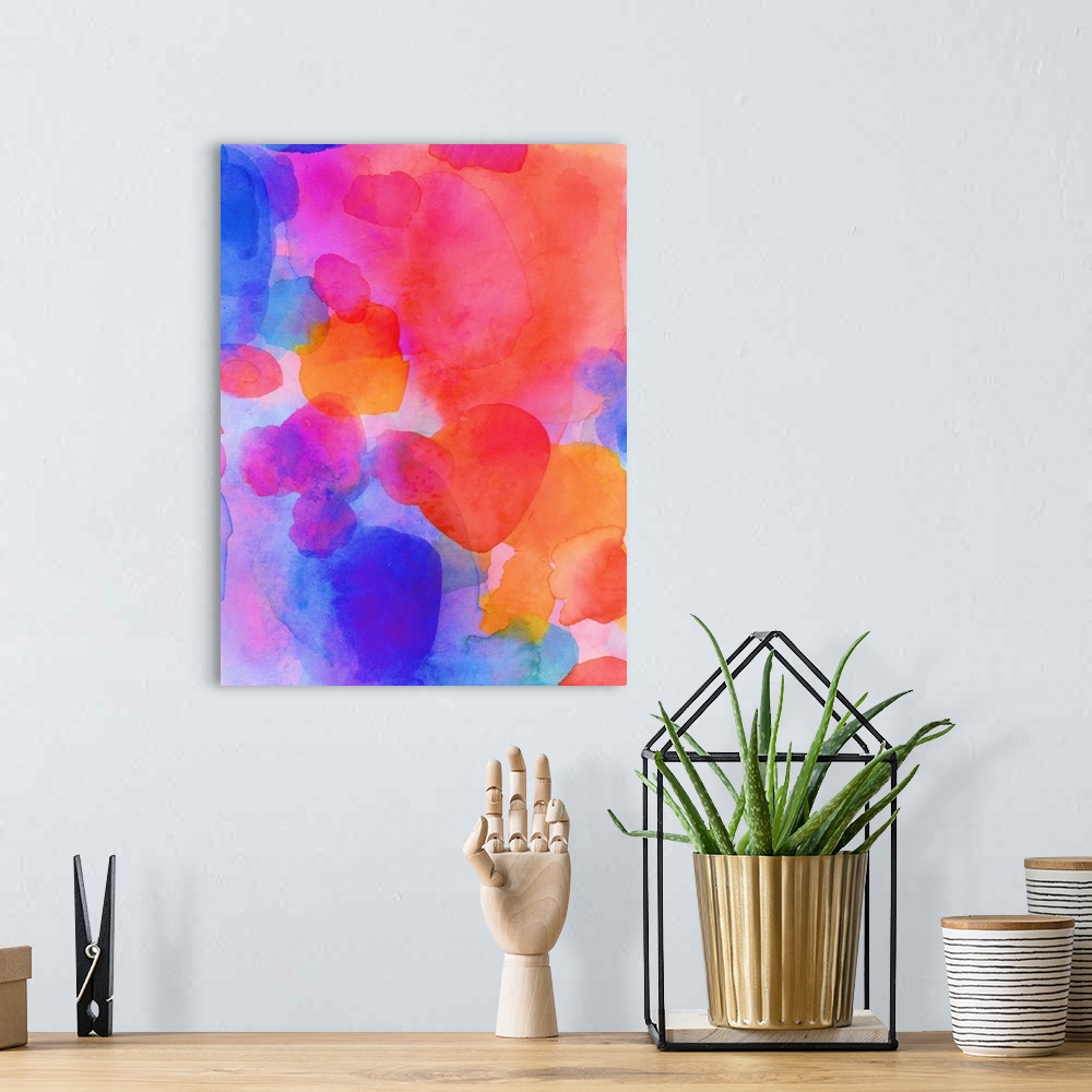 A bohemian room featuring A vertical abstract watercolor painting in brilliant colors of pink, orange and blue.