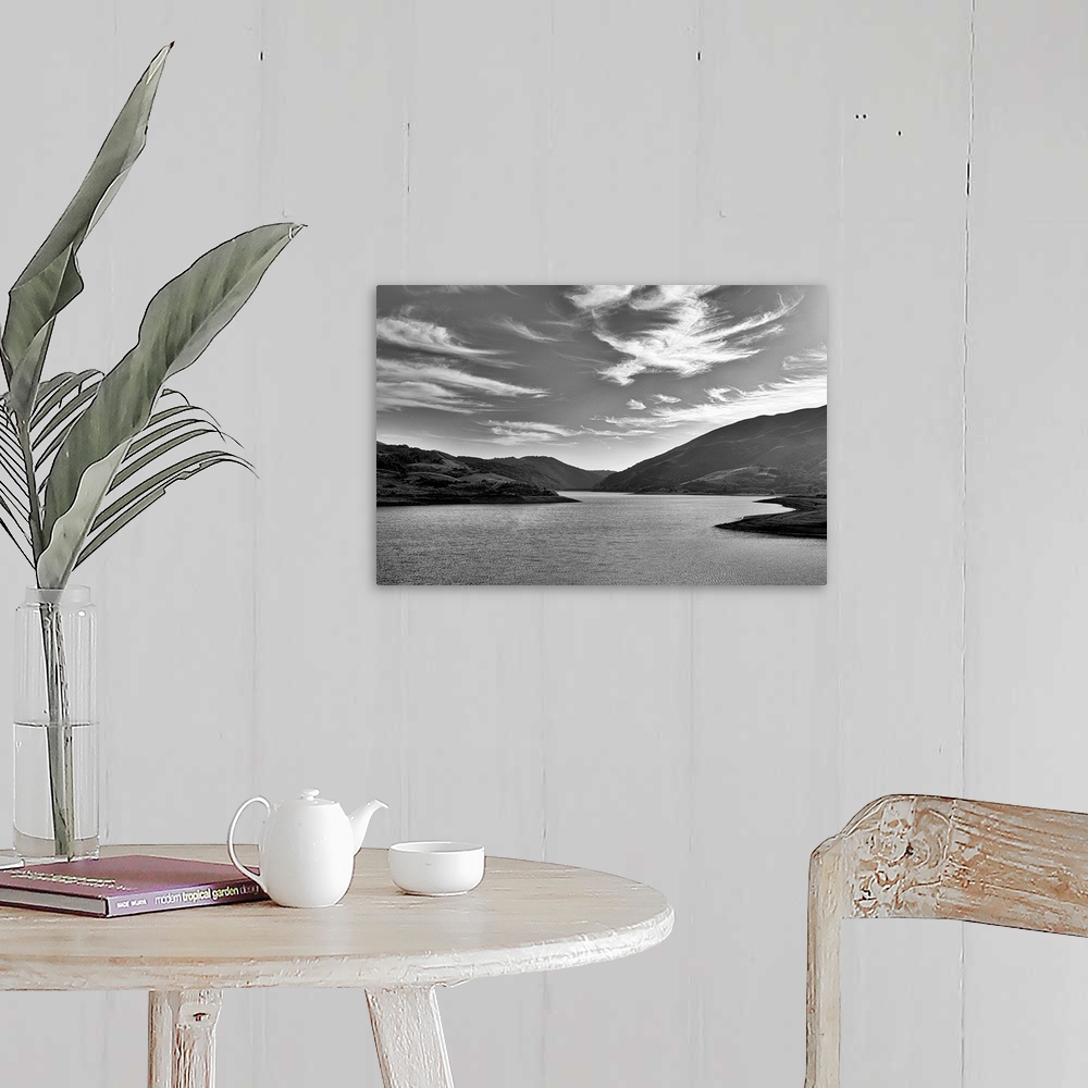 A farmhouse room featuring A black and white landscape with a sky full of clouds.
