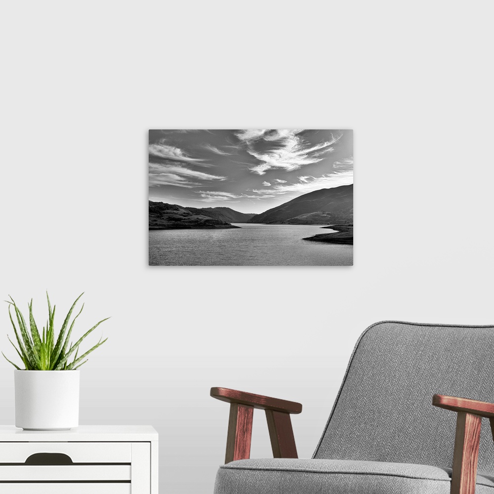 A modern room featuring A black and white landscape with a sky full of clouds.