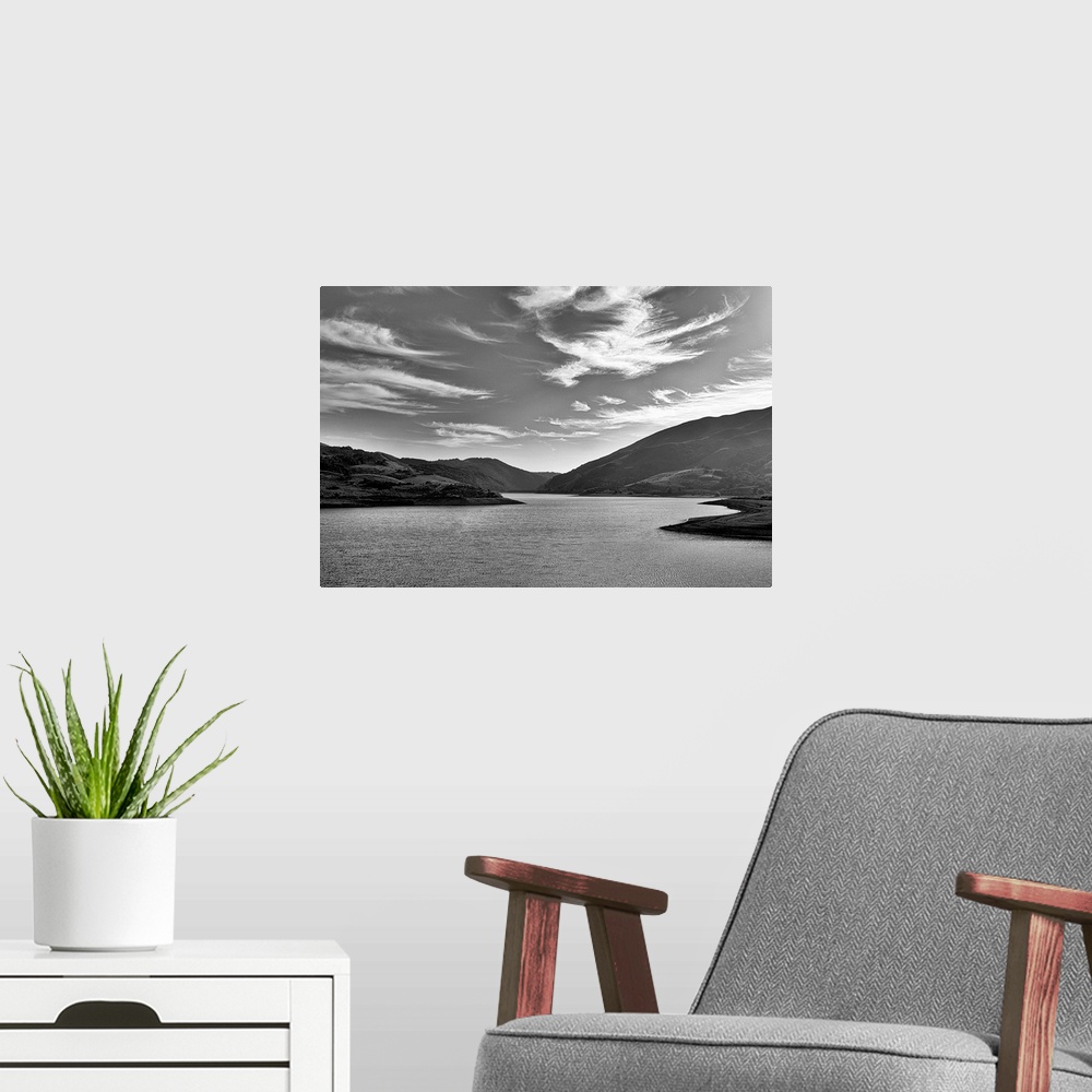A modern room featuring A black and white landscape with a sky full of clouds.