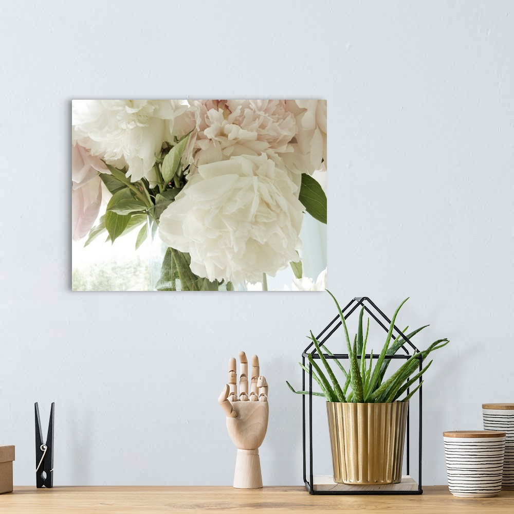 A bohemian room featuring A close up photograph of a bouquet of pale pink and white flowers.