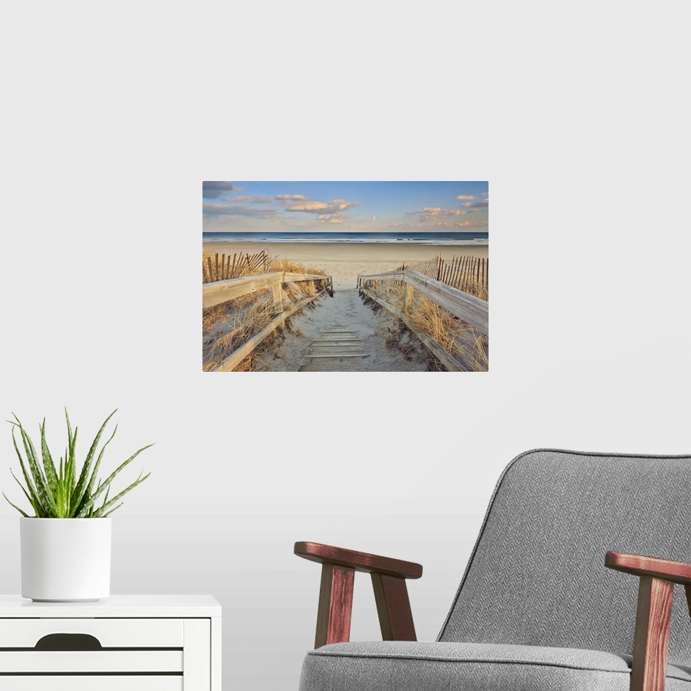 A modern room featuring A photograph of an idyllic scene with a wooden walkway leading down to a sandy secluded beach.