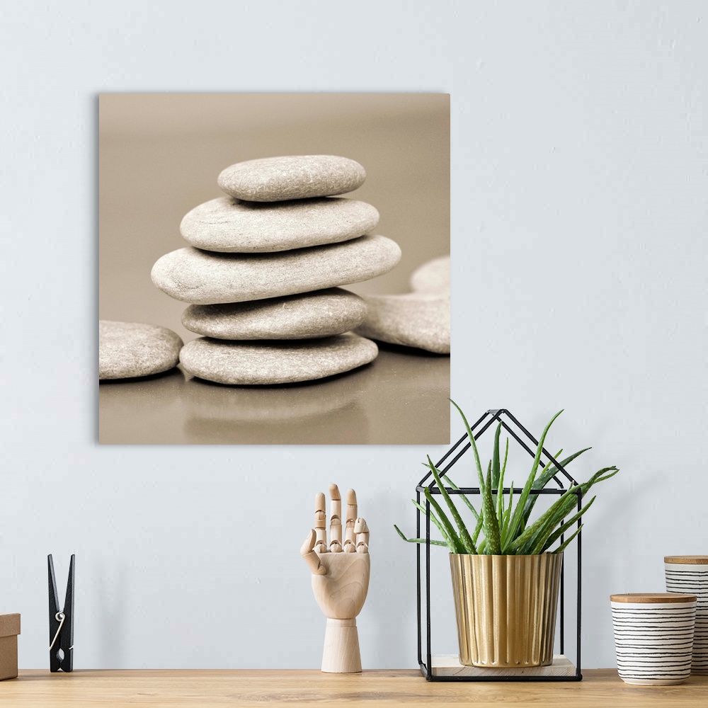 A bohemian room featuring Square monotone image of a stack on smooth rocks.