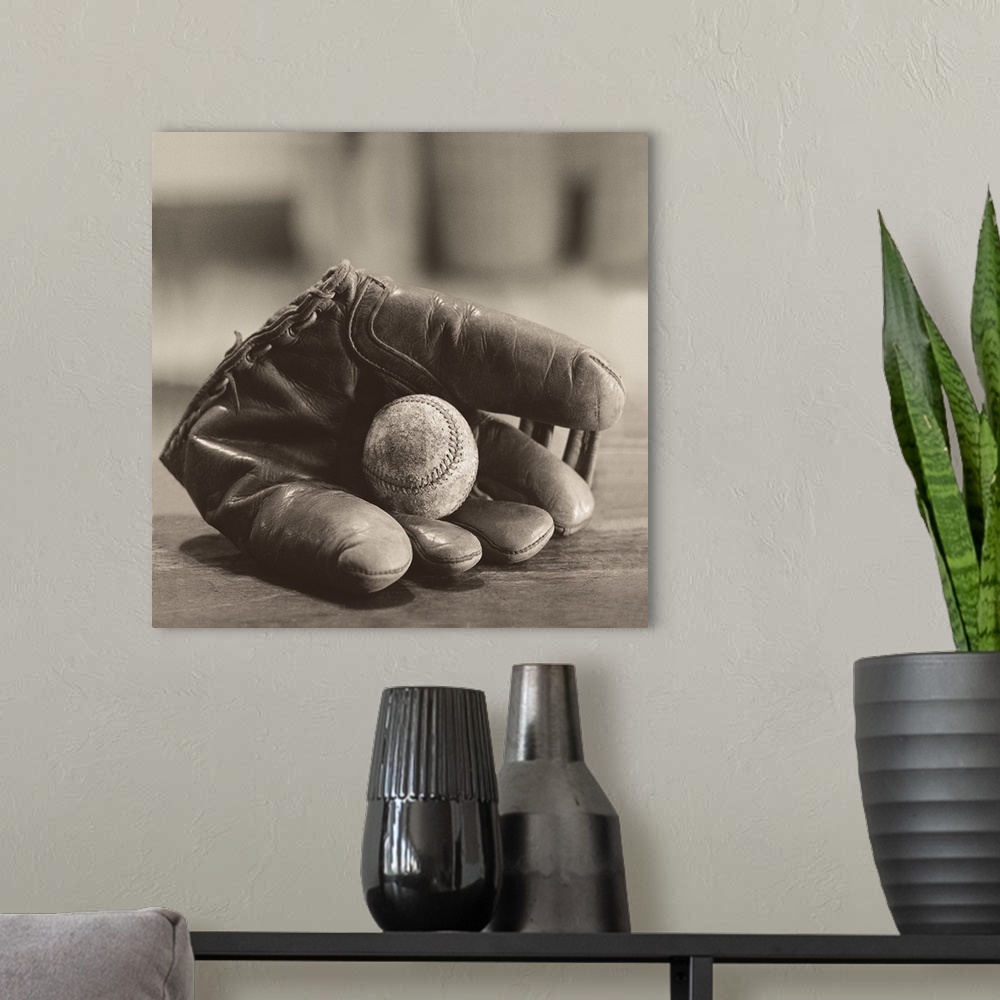 A modern room featuring Photograph in sepia tones of a baseball mitt with a baseball by Judy B. Messer.