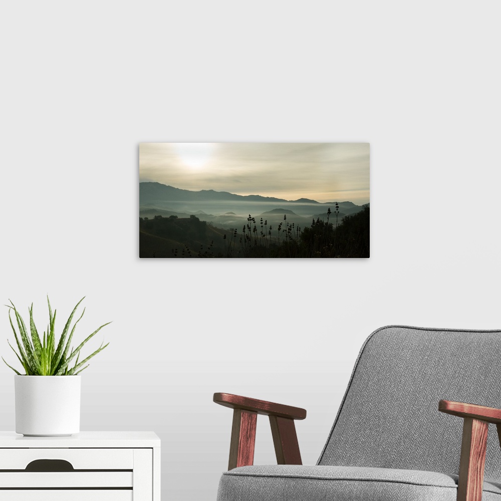 A modern room featuring Photograph of fog in the mountain with darks and lights reflecting on the clouds.