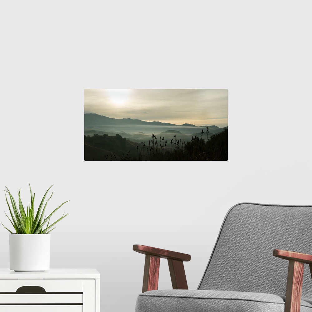 A modern room featuring Photograph of fog in the mountain with darks and lights reflecting on the clouds.