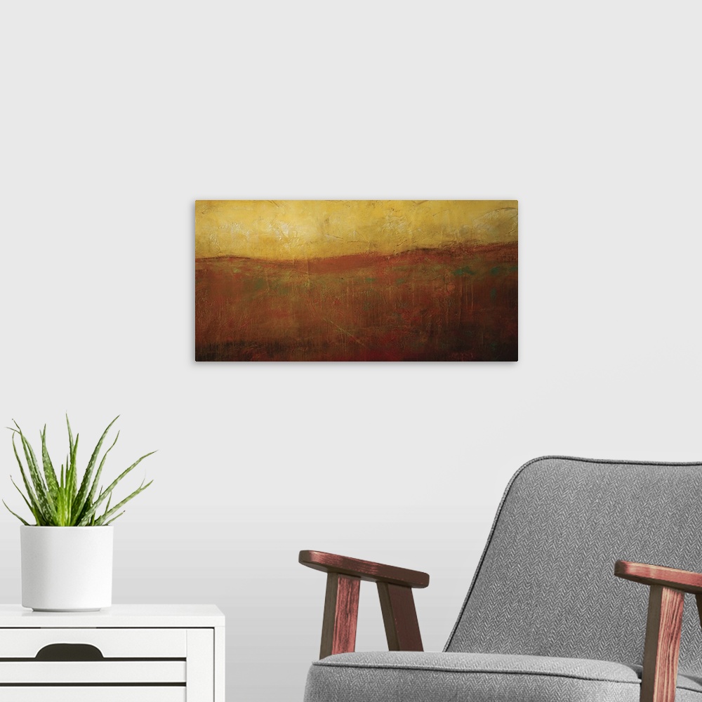 A modern room featuring Abstract artwork of a golden hued sunrise illuminating a smoky orange hilltop.