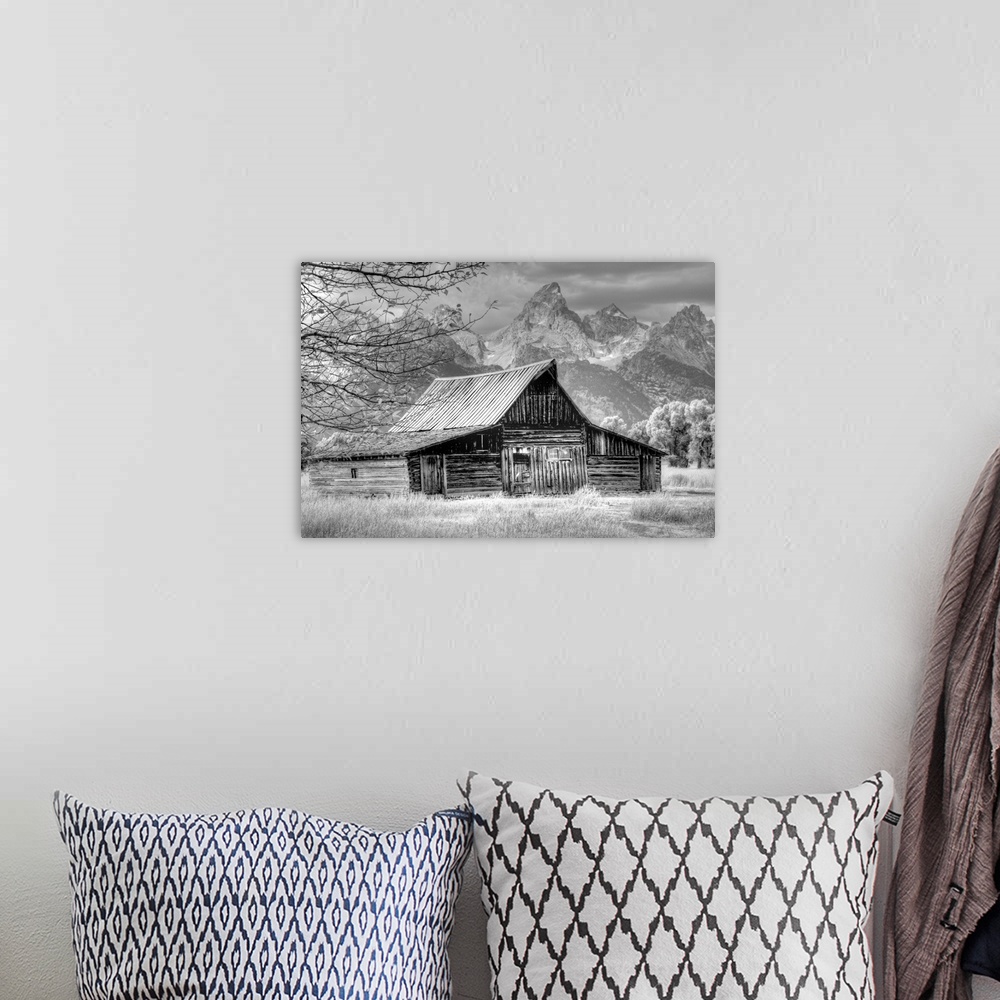 A bohemian room featuring Black and white photo of an old barn in a field with the Grand Teton mountain range in the distance.