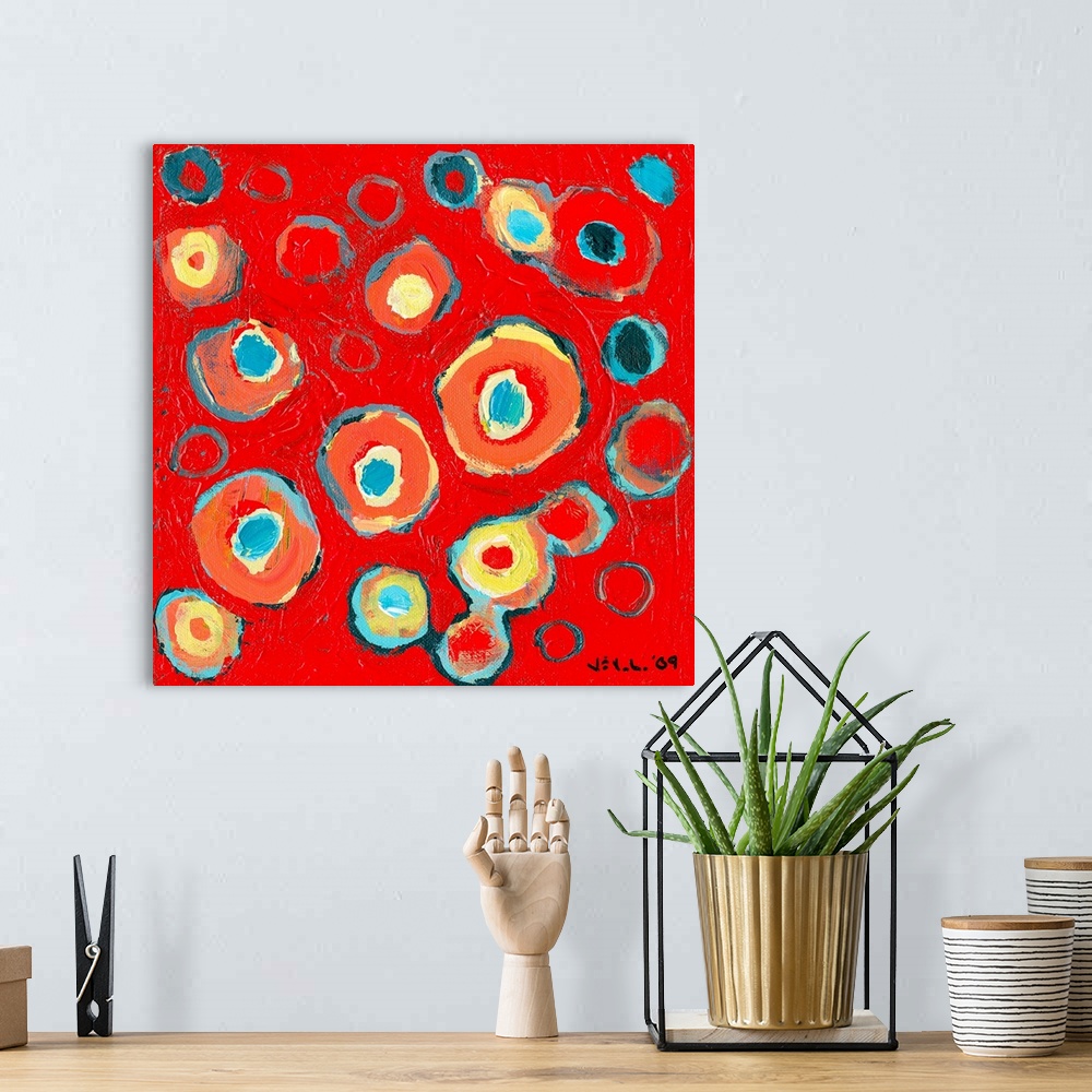 A bohemian room featuring Large abstract painting featuring various vibrantly-colored circular designs inside one another o...