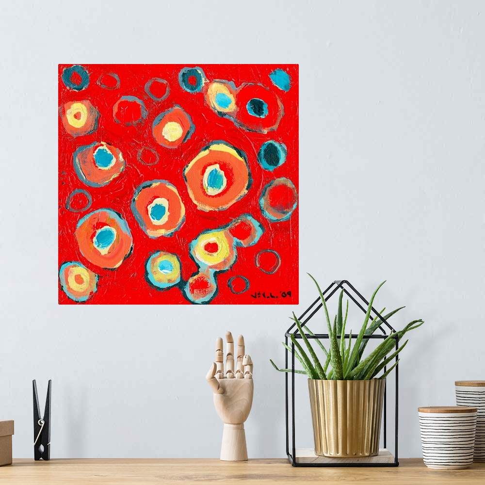 A bohemian room featuring Large abstract painting featuring various vibrantly-colored circular designs inside one another o...