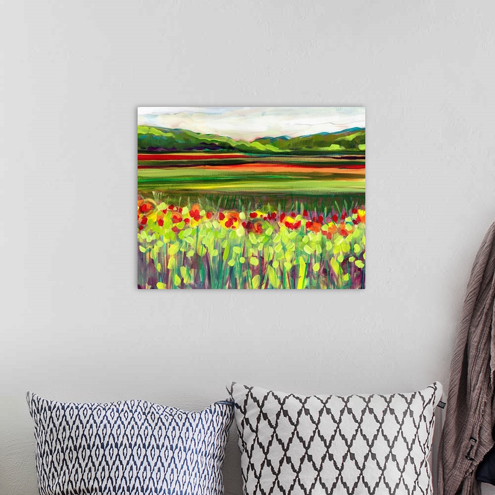 A bohemian room featuring Large, landscape fine art painting of a meadow of wildflowers in front of a green hillside on the...