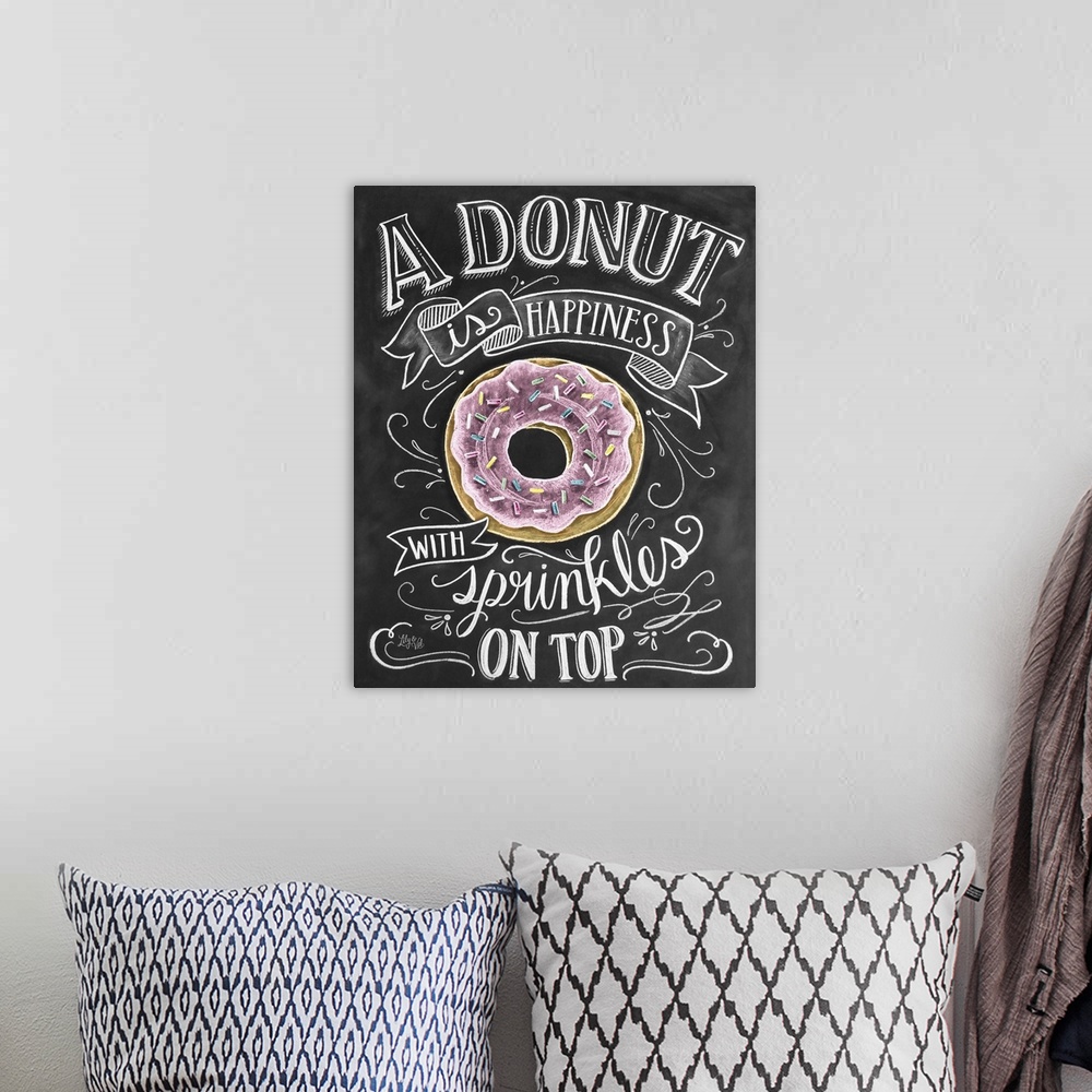 A bohemian room featuring "A donut is happiness with sprinkles on top" handwritten in white chalk with a drawing of a donut.