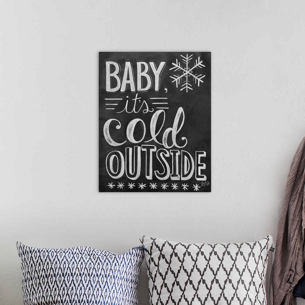 A bohemian room featuring "Baby, it's cold outside" handwritten in white chalk on a black background.