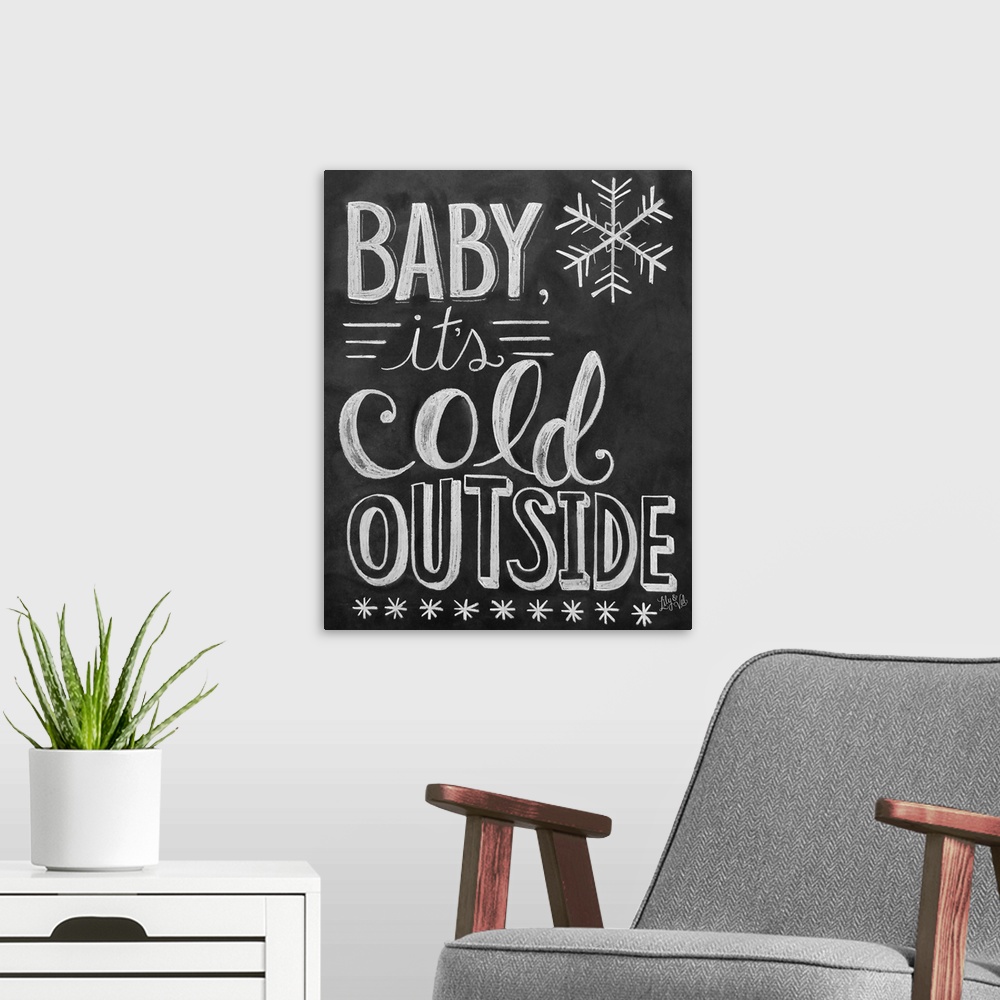 A modern room featuring "Baby, it's cold outside" handwritten in white chalk on a black background.