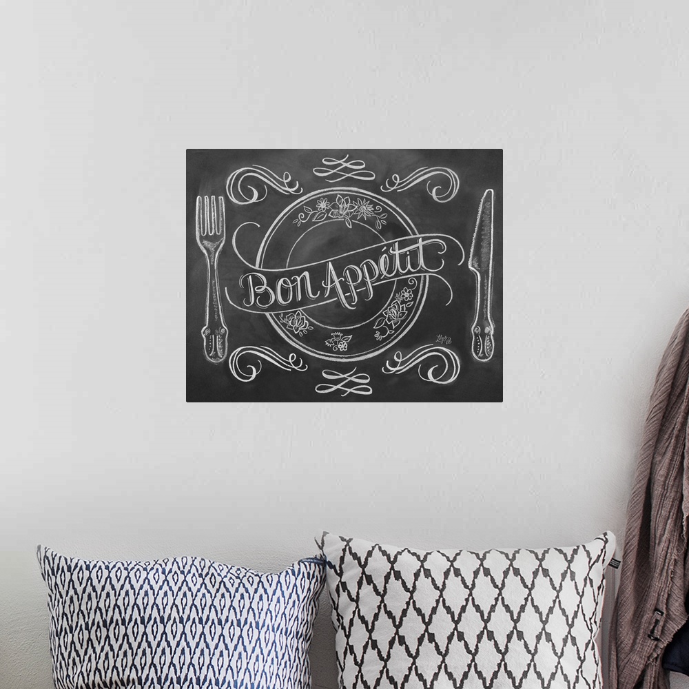 A bohemian room featuring "Bon Appetit" handwritten on a drawing of a place setting in white chalk on a black background.