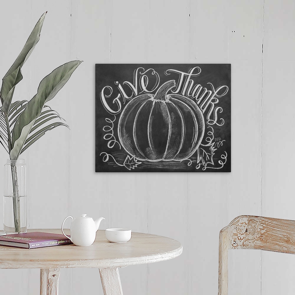 A farmhouse room featuring "Give Thanks" handwritten with a drawing of a large pumpkin in white chalk on a black background.