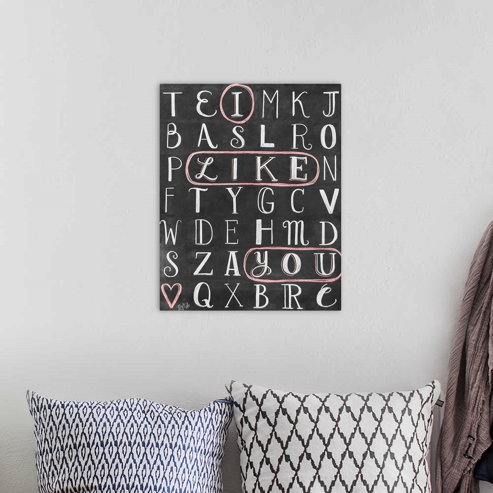 A bohemian room featuring The words "I Like You" circled in a word-search puzzle, hand written in chalk o na black background.