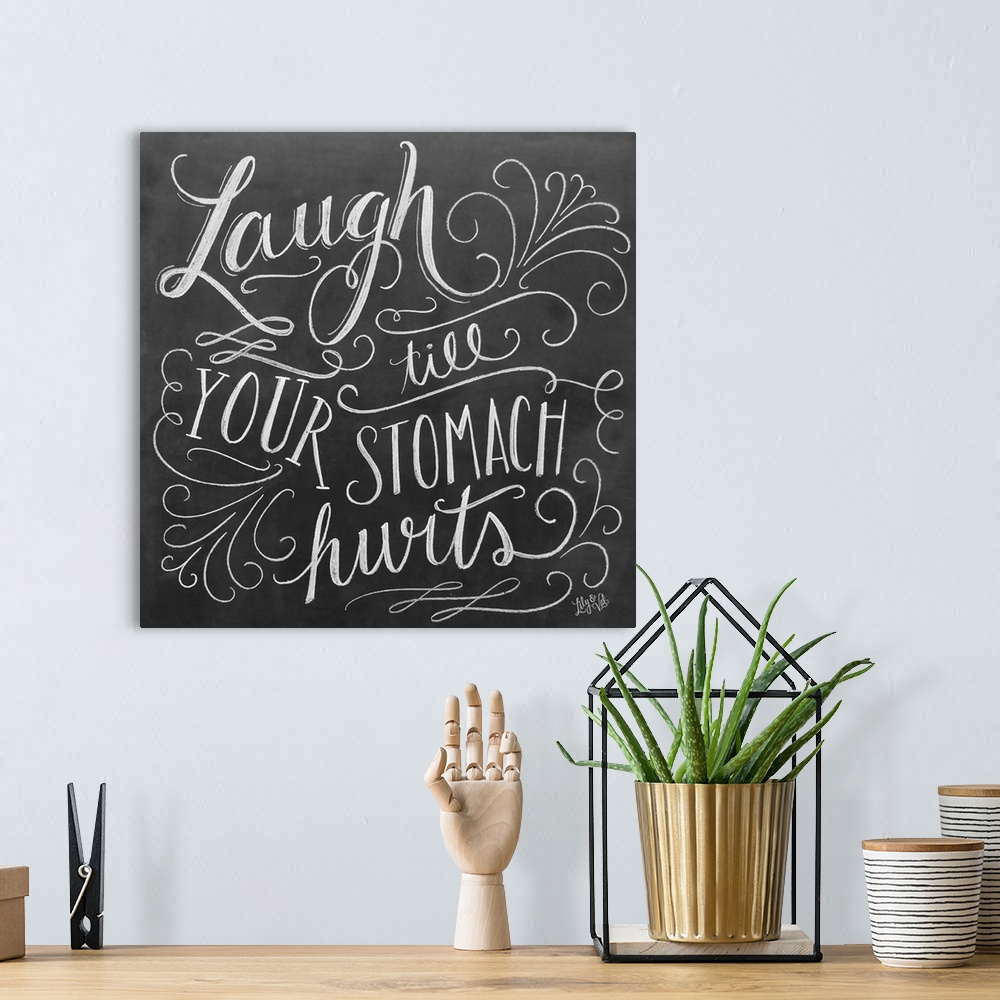 A bohemian room featuring The phrase "Laugh till your stomach hurts" done in flowing hand-lettering in white chalk on a dar...