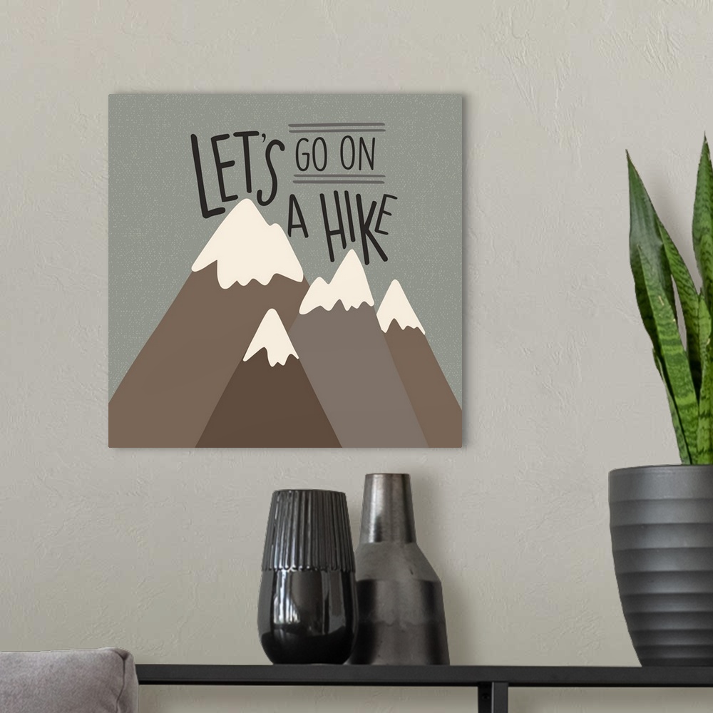 A modern room featuring "Let's go on a hike" written above a simple drawing of mountains.