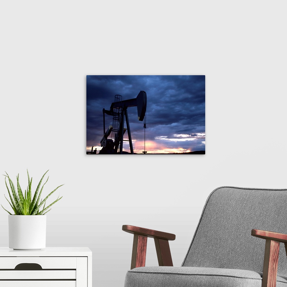A modern room featuring An oil rig silhouetted at sunset.
