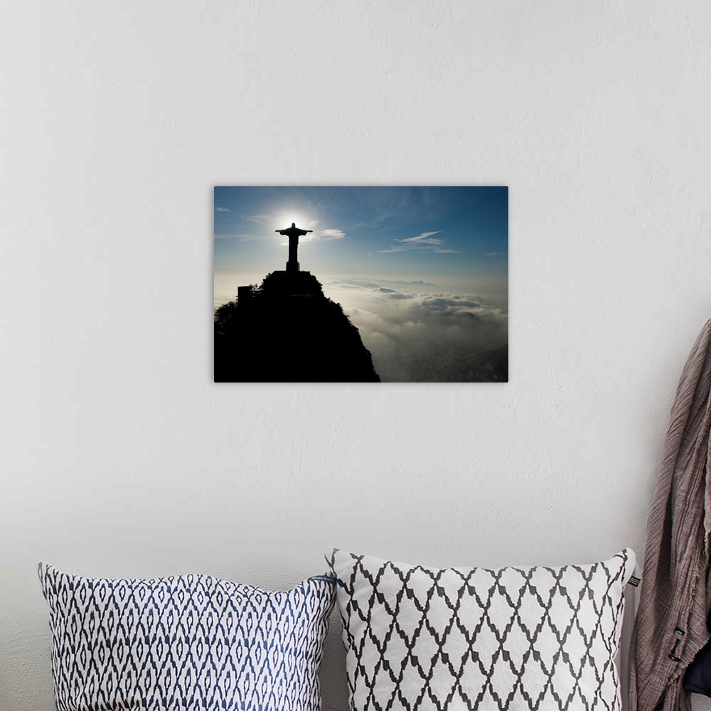 A bohemian room featuring Christ the Redeemer Statue at sunrise above the clouds.