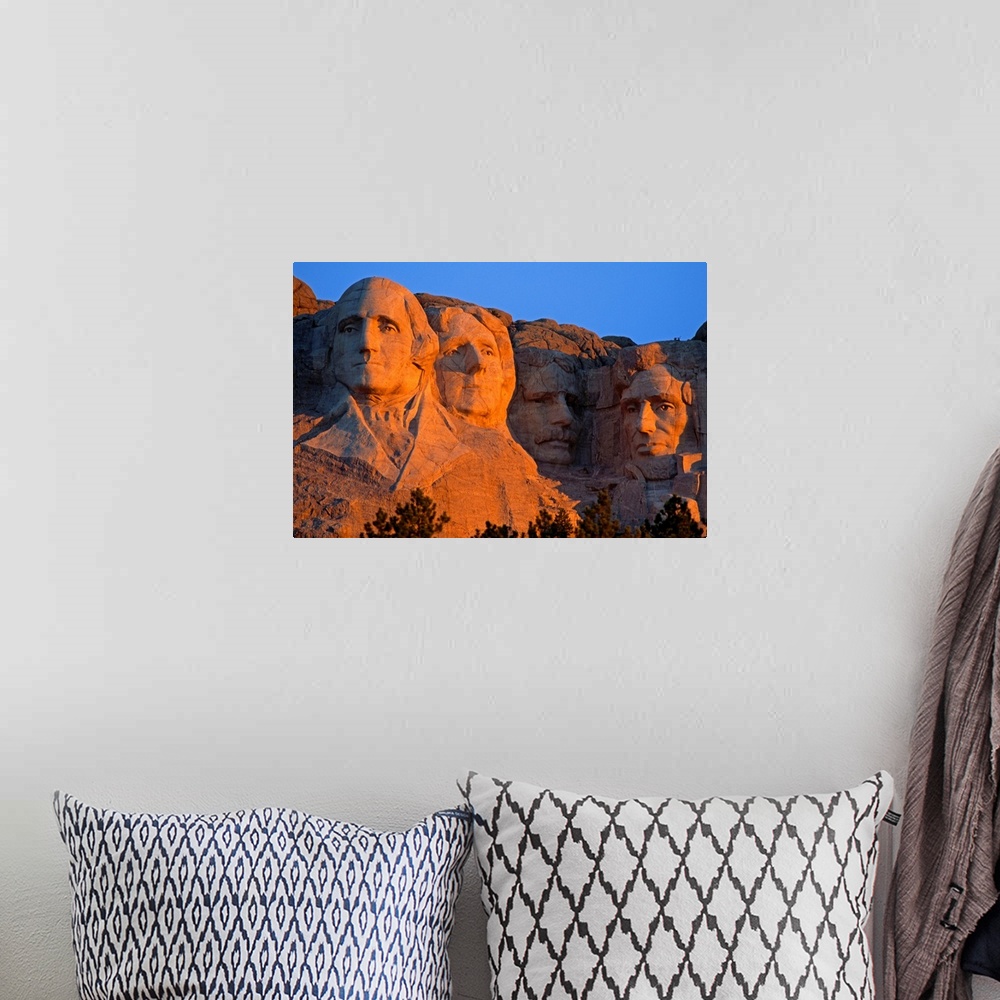 A bohemian room featuring A picture taken of Mount Rushmore as the sun begins to set and shines on the faces in the mountain.