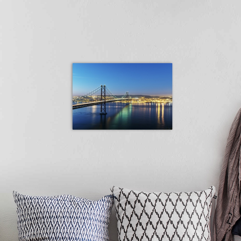 A bohemian room featuring 25th of April Bridge over the Tagus river (Tejo river) and Lisbon at twilight. Portugal.