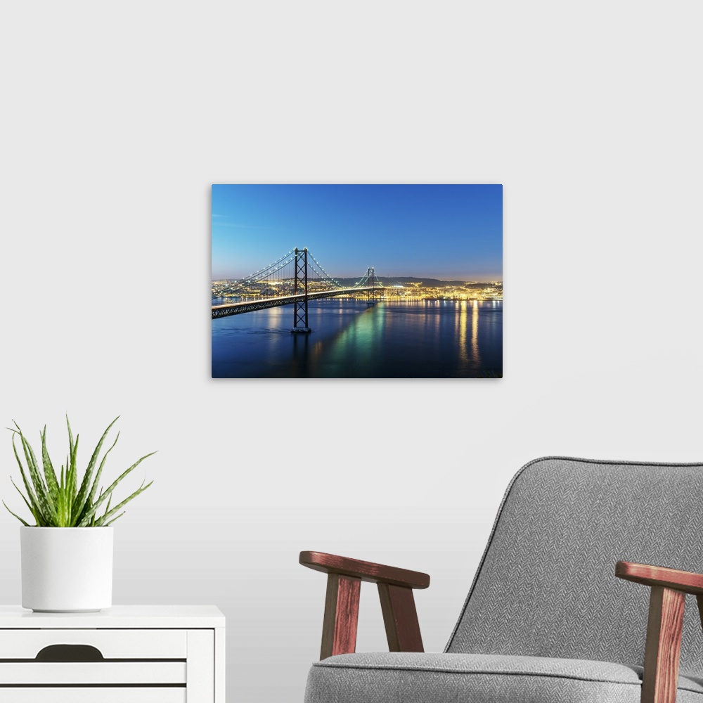 A modern room featuring 25th of April Bridge over the Tagus river (Tejo river) and Lisbon at twilight. Portugal.
