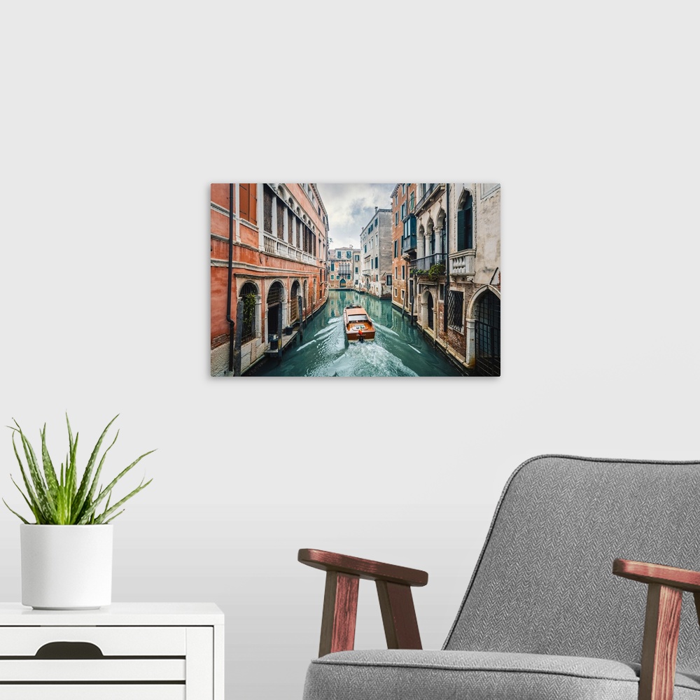 A modern room featuring A boat cruising a green canal in Venice, Veneto, Italy