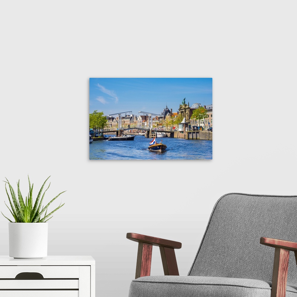 A modern room featuring Netherlands, North Holland, Haarlem. A boat in front of the Gravestenenbrug drawbridge on the Spa...