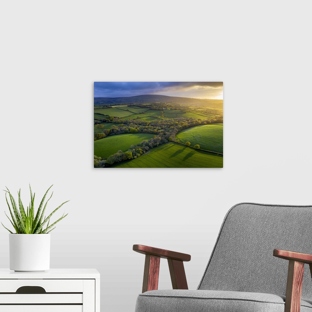 A modern room featuring Aerial photo of rolling countryside in evening light, Livaton, Devon, England. Spring (April) 2019.