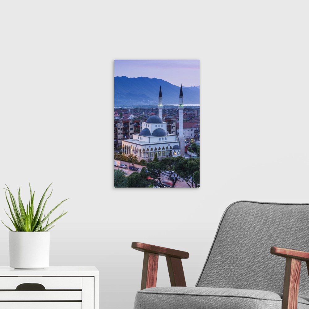 A modern room featuring Albania, Shkodra, elevated view of Zogu 1 Boulevard and mosque, dusk