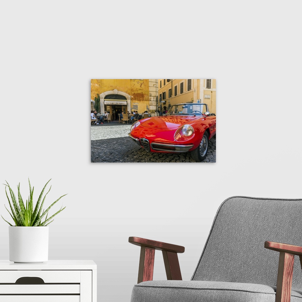 A modern room featuring Alfa Romeo Duetto spider parked in a cobblestone street of Rome, Lazio, Italy.