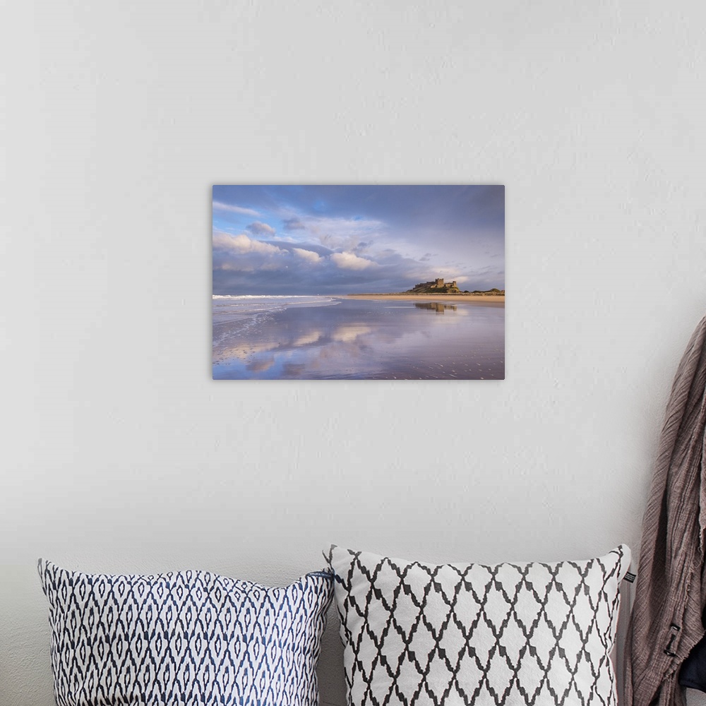 A bohemian room featuring Bamburgh Castle reflected in Bamburgh Beach, Northumberland, England. Spring
