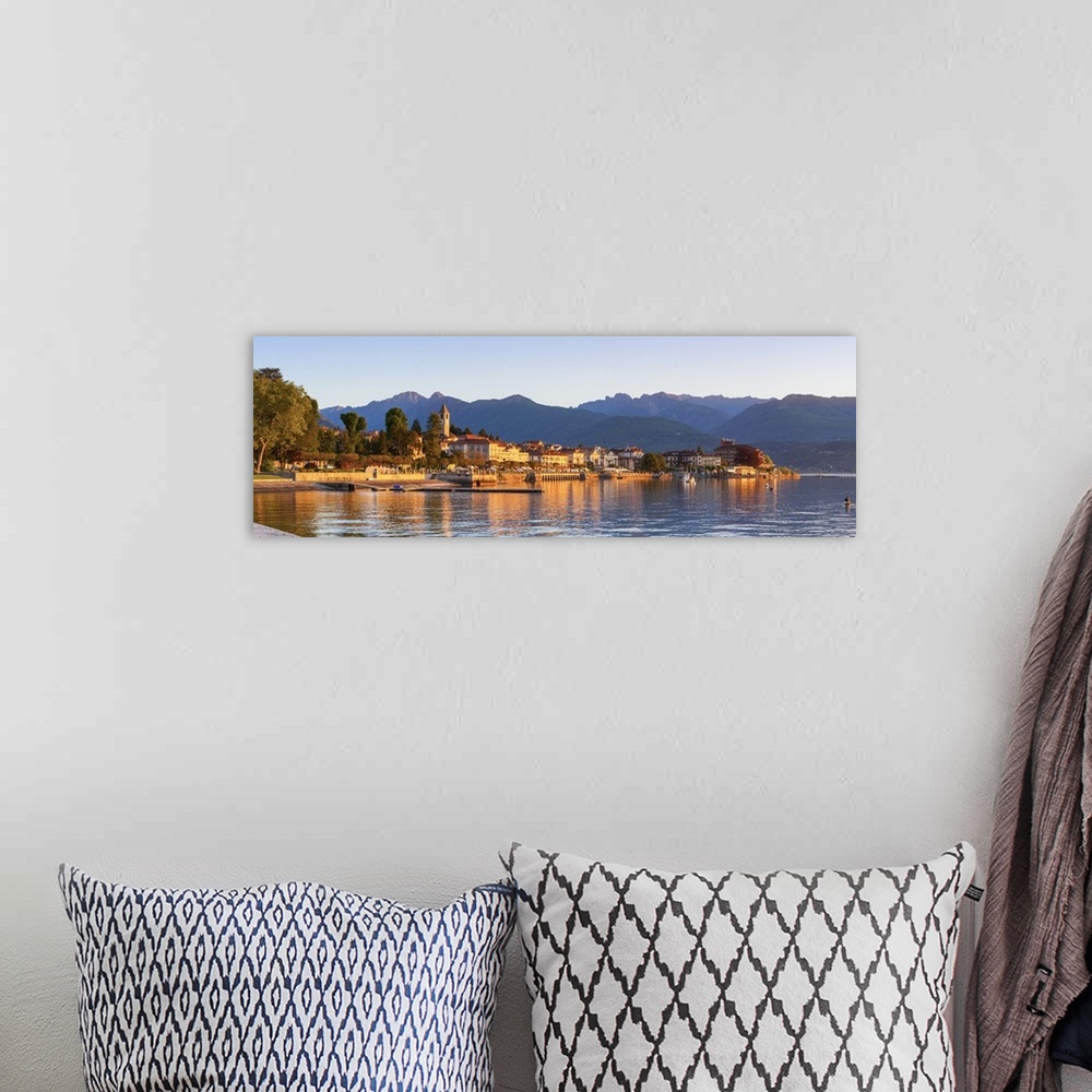 A bohemian room featuring The idyllic lakeside village of Baveno illuminated at sunrise, Lake Maggiore, Piedmont, Italy.