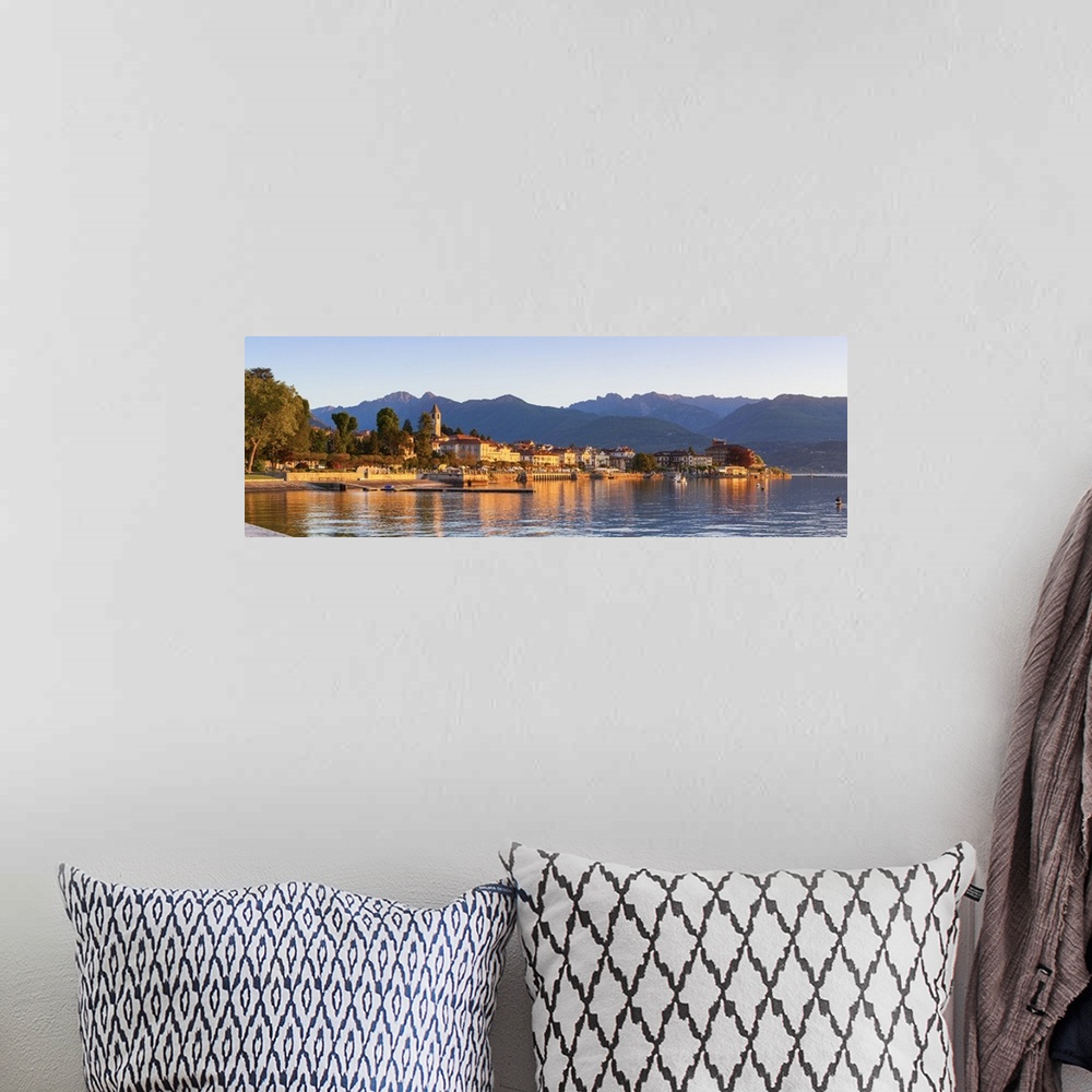 A bohemian room featuring The idyllic lakeside village of Baveno illuminated at sunrise, Lake Maggiore, Piedmont, Italy.