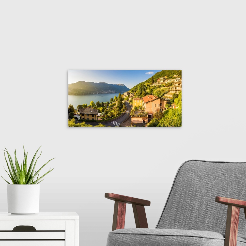 A modern room featuring Blevio, lake Como, Como province, Lombardy, Italy. The winding coastal road at sunset.