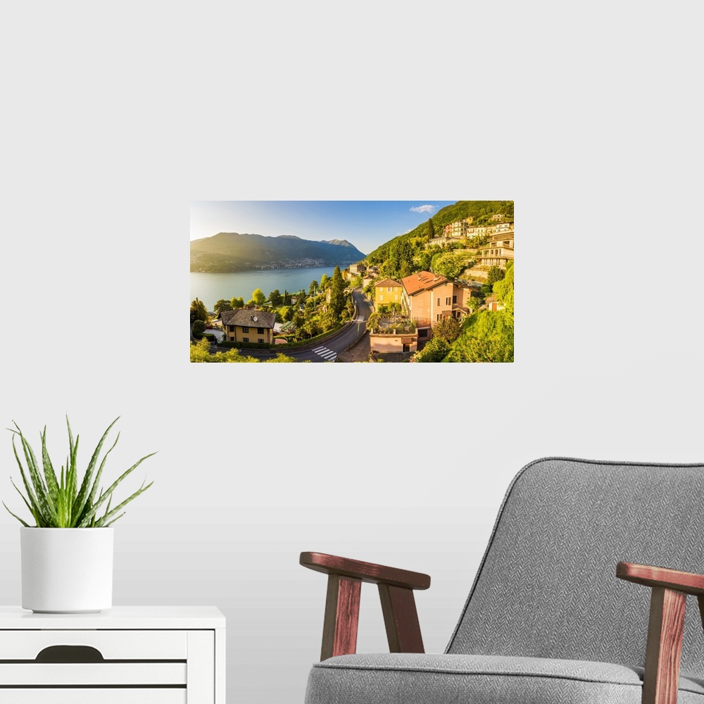 A modern room featuring Blevio, lake Como, Como province, Lombardy, Italy. The winding coastal road at sunset.
